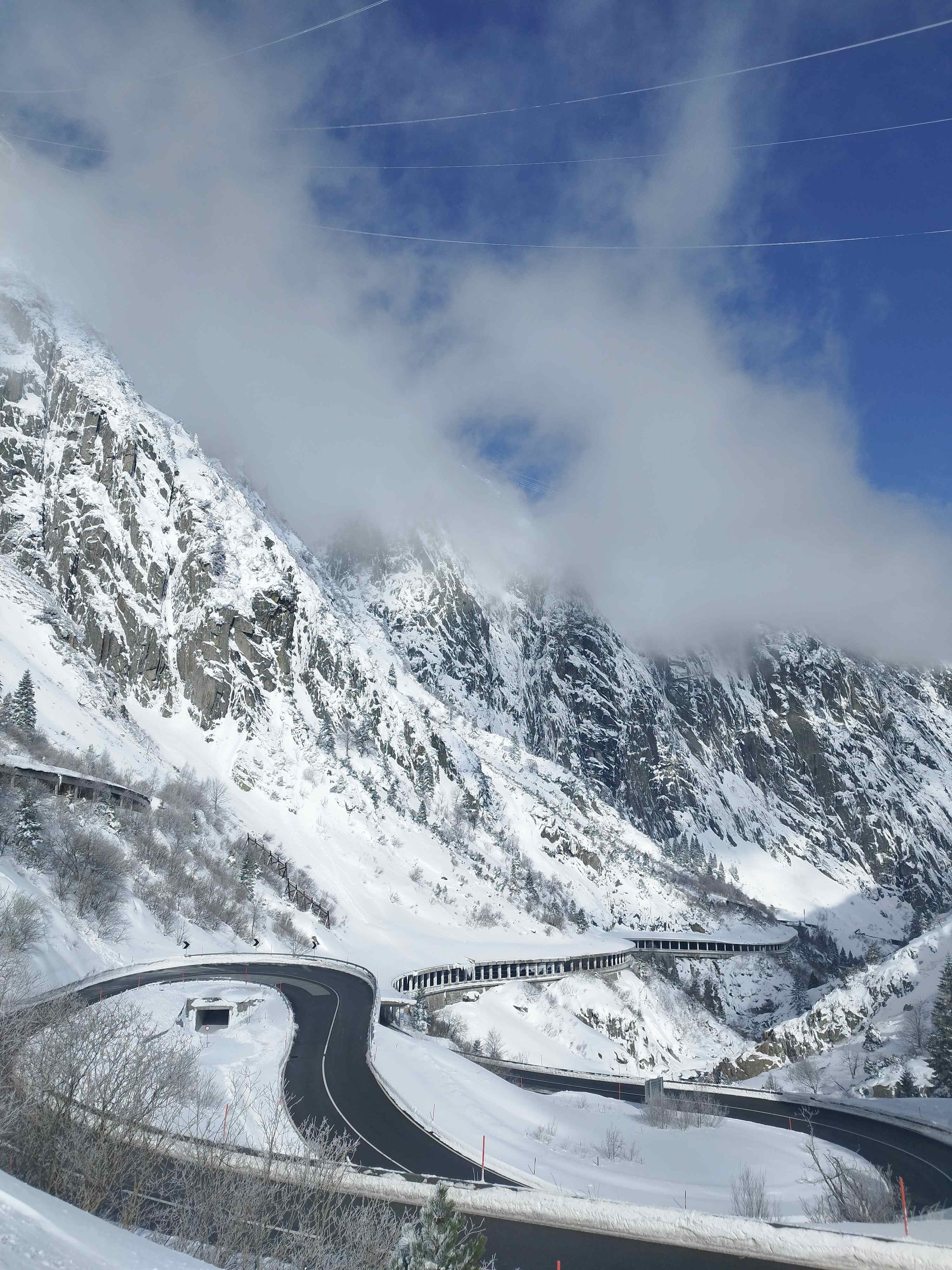 Panoramic view of the spectacular snowy mountain road winding through the Schöllenen Gorge towards Andermatt